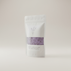 Professional e-commerce product photography of a **brandless** Lavender Bath Salts Premium Bag (A calming soak to unwind after a long day.). The entire environment is a perfectly uniform, flat, solid color #EAE9E7 (light warm gray) with absolutely no gradient, vignette, spotlighting, texture, noise, or grain. The object is centered and tiny, occupying only 25% of the frame, surrounded by massive negative space. The background and floor are a seamless, infinite cyclorama of solid color #EAE9E7 with no horizon line, no corner, and no visible wall/floor transition. Lighting: ultra-even high-key with very strong global illumination and soft, multi-directional bounced fill (studio light tent look). Bright exposure (lifted midtones and shadows, low contrast), slightly overexposed overall while preserving product detail. Fully diffuse, no hard shadows, no cast shadows; at most a barely visible neutral contact shadow. No harsh specular highlights. Framing: simple 3/4 view. Perfectly centered. Style: ultra-clean, minimalistic. No logos, no text, no distractions. 8k resolution, sharp details on the object.