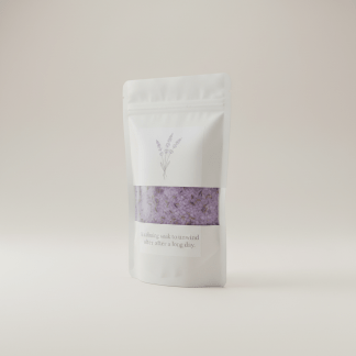 Professional e-commerce product photography of a **brandless** Lavender Bath Salts Premium Bag (A calming soak to unwind after a long day.). The entire environment is a perfectly uniform, flat, solid color #EAE9E7 (light warm gray) with absolutely no gradient, vignette, spotlighting, texture, noise, or grain. The object is centered and tiny, occupying only 25% of the frame, surrounded by massive negative space. The background and floor are a seamless, infinite cyclorama of solid color #EAE9E7 with no horizon line, no corner, and no visible wall/floor transition. Lighting: ultra-even high-key with very strong global illumination and soft, multi-directional bounced fill (studio light tent look). Bright exposure (lifted midtones and shadows, low contrast), slightly overexposed overall while preserving product detail. Fully diffuse, no hard shadows, no cast shadows; at most a barely visible neutral contact shadow. No harsh specular highlights. Framing: simple 3/4 view. Perfectly centered. Style: ultra-clean, minimalistic. No logos, no text, no distractions. 8k resolution, sharp details on the object.